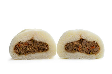 Two halves of the same steamed bao bun showing filling isolated on white background