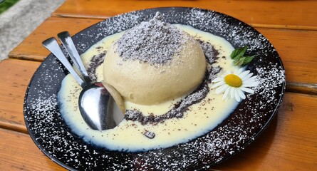 Germknödel - sweet Austrian dumpling filled with jam served with vanilla sauce, poppy seeds and butter