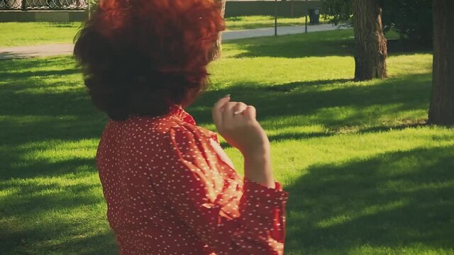 Come-with-me gesture. Young nice girl asking follow her in summer park. Slow motion shot.