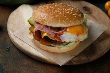 Juicy burger with egg on a wooden background