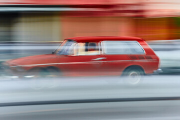 Fototapeta na wymiar Car, model VW Volkswagen Variant color red, traveling at high speed, red and light blue trails, panning