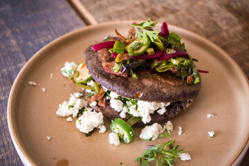 Gordita made with blue corn masa stuffed with chicharron, short rib, and cheese at a restaurant in Mexico City