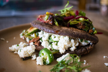Gordita made with blue corn masa stuffed with chicharron, short rib, and cheese at a restaurant in Mexico City
