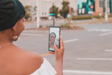 Smiling African woman taking a selfie with a smartphone