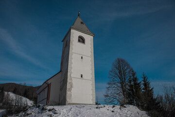 Panoramic view of Catholic church of Holy Ahacij in Kalise, Slovenia on a sunny winter day with some snow visible. Cold but warm feeling.