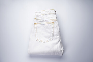 White folded denim pants, back pocket, top view.
