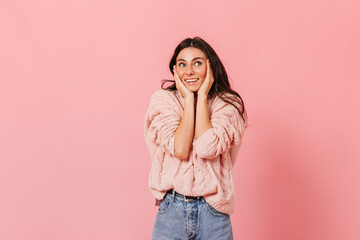 Portrait of tanned brunette girl in pink sweater in high spirits posing on isolated background