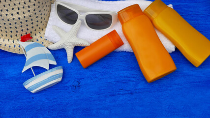 Hut Sonnenbrille und Sonnenmilch auf einem Handtuch