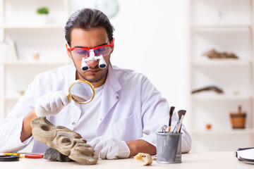 Young male archaeologist studying ancient african stonemask