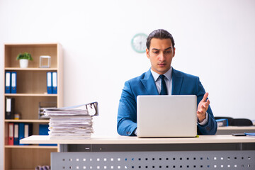 Young male employee unhappy with excessive work in the office