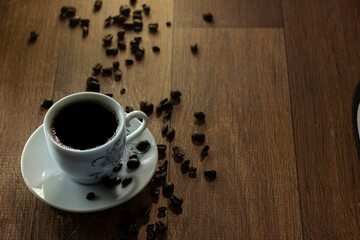 Closeup of Typical Brazilian Coffee Cup and Coffee Beans on a Wooden Table