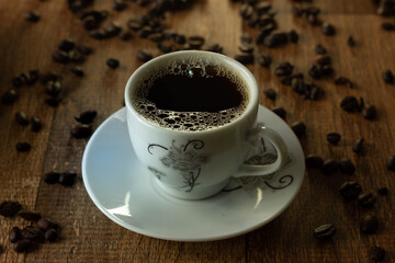 Closeup of Typical Brazilian Coffee Cup and Coffee Beans on a Wooden Table