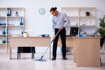 Young male employee cleaning office during pandemic