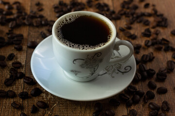 Closeup of Typical Brazilian Coffee Cup and Coffee Beans on a Wooden Table