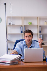 Young male employee suffering at workplace