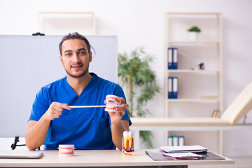 Young male doctor teacher dentist in front of whiteboard