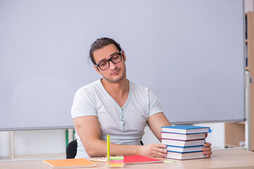 Young male teacher student sitting in the classroom