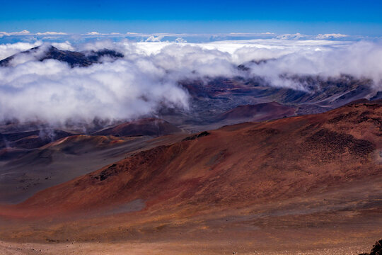 Clouds fill in the crater covering the beautiful colors seen in the massive volcanic crater at Haleakala National Park on the island of Maui, Hawaii