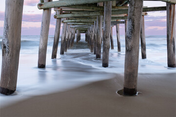 The Sandbridge Fishing Pier in Virginia Beach at sunset, with long exposure making the water silky and dreamy