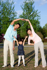 Happy family doing aerobics in park