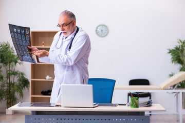 Old male doctor radiologist working in the clinic