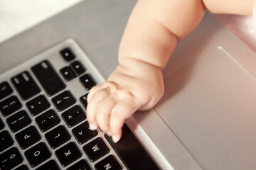 Baby touching computer keyboard