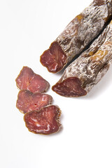 Dried sausage sliced into slices on a white plate. Elite meat product