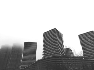 Low angle grayscale shot of commercial buildings against white background