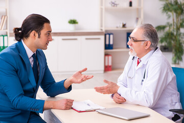 Obraz premium Young businessman meeting with old doctor