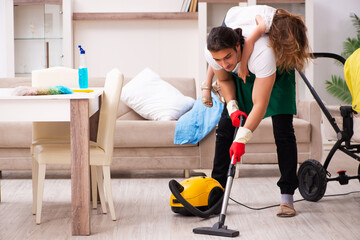 Young male contractor cleaning the house with his small daughter