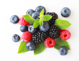Various fresh berries isolated on white background. Raspberry, Blueberry, Cranberry, Blackberry and Mint leaves