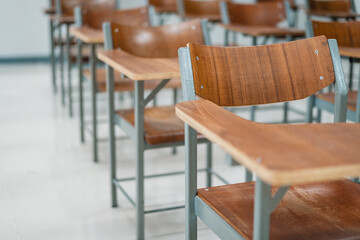 Empty university classroom with many wooden chairs. Wooden chairs well arranged in college...