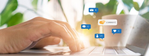 Hand typing keyboard with laptop computer with social media and Marketing virtual icons.