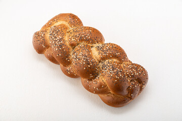 Wheat bread wicker sprinkled with sesame seeds with cereals on a light background