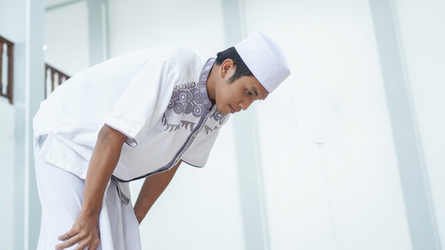A portrait of an asian muslim man pray at mosque, the pray name is sholat, rukuk movement
