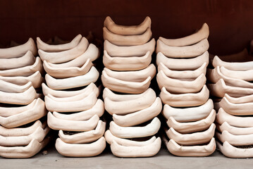Freshly molded clay kitchenwares on display and sold in a pottery workshop