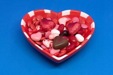 Some candy and chocolat in an heart shape bowl for Valentine's day