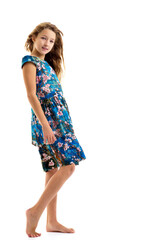 A beautiful little girl stands in the wind, her hair and clothes are developing greatly.