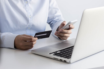 Asian women are filling out credit card information on their mobile phones to pay for Internet purchases using their credit card.