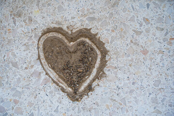 Dust and debris were swept pile up and painted in a heart shape on the terrazzo floor of the house.
