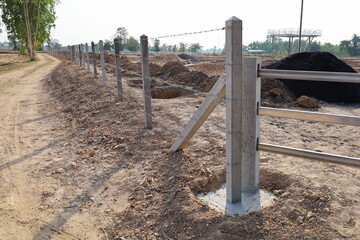 Post and base of the fence. Concrete pillar base to strengthen the newly built outdoor barbed wire...