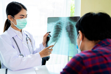Female doctor is looking at an X-Ray radiograph for pain and is consulting with a patient