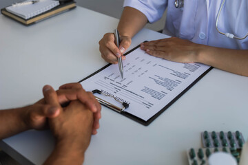 The doctor is explaining the treatment after examining the patient. Talk to the patient and check the information on the physical examination papers. Disease treatment concept.