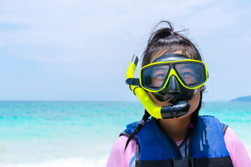 A cute Asian woman enjoying a snorkel mask at the beach on a sunny day