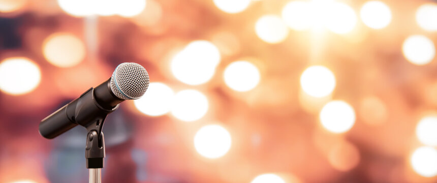 Public Speaking Backgrounds, Close-up The Microphone On Stand For Speaker Speech Presentation Stage Performance With Blur And Bokeh Light Background.