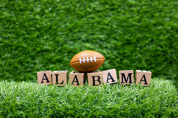 American football with ALABAMA word on green grass