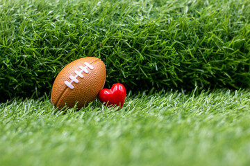 Football for Valentine's Day with love on green grass