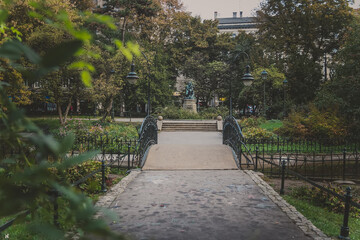 Planty small park located in the old town of Krakow, Poland. Park alley around Wawel Castle. Park path with small bridge across the pond and old beautiful lanterns on a warm autumn day