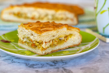 Piece of pie with cabbage and fish on a plate