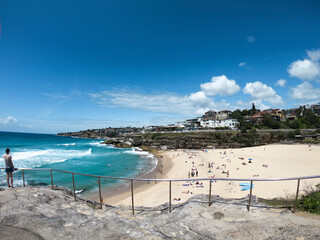 Fototapeta na wymiar Sydney, beach, ocean, blue water, famous, sand, building, rocks, clouds, bush, green, grass